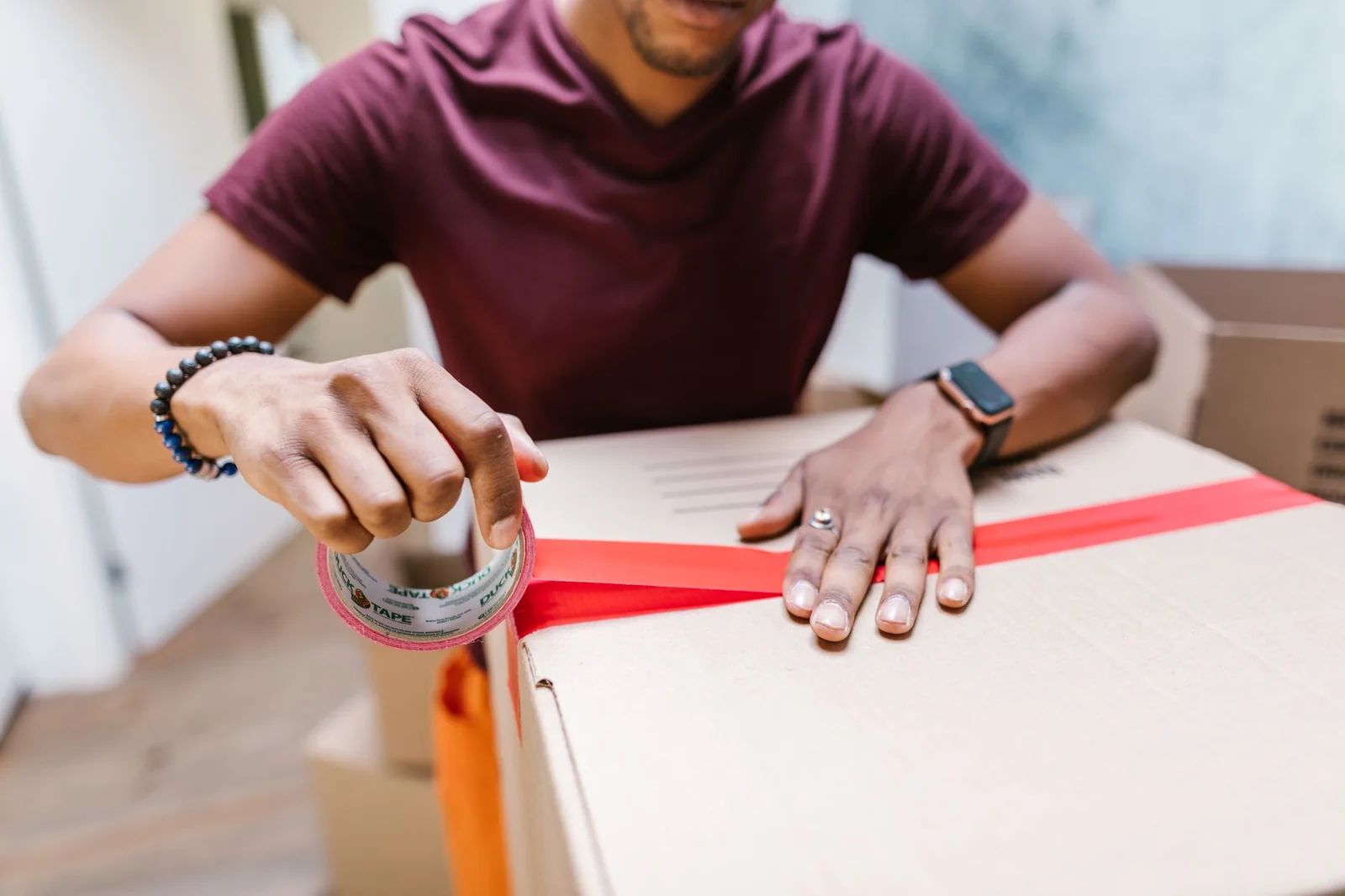 Personne mesurant un empilement de cartons dans un box de stockage avec un mètre ruban